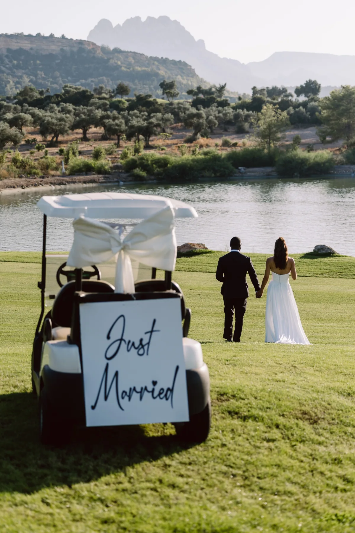 'Just Married' tabelalı golf arabası ve uzaklaşan çift, Korineum Golf & Beach Resort — Mert Gardiyanoğlu Photography
