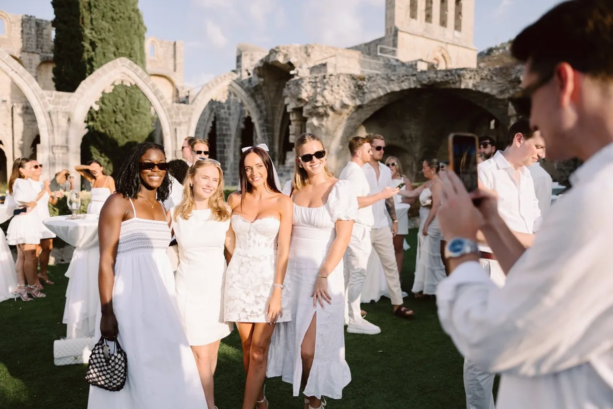 Wedding ceremony in front of ancient ruins in Cyprus, guests dressed in white