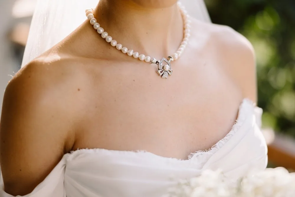 Wedding detail photography in Cyprus — heirloom pearl necklace on a bridal gown