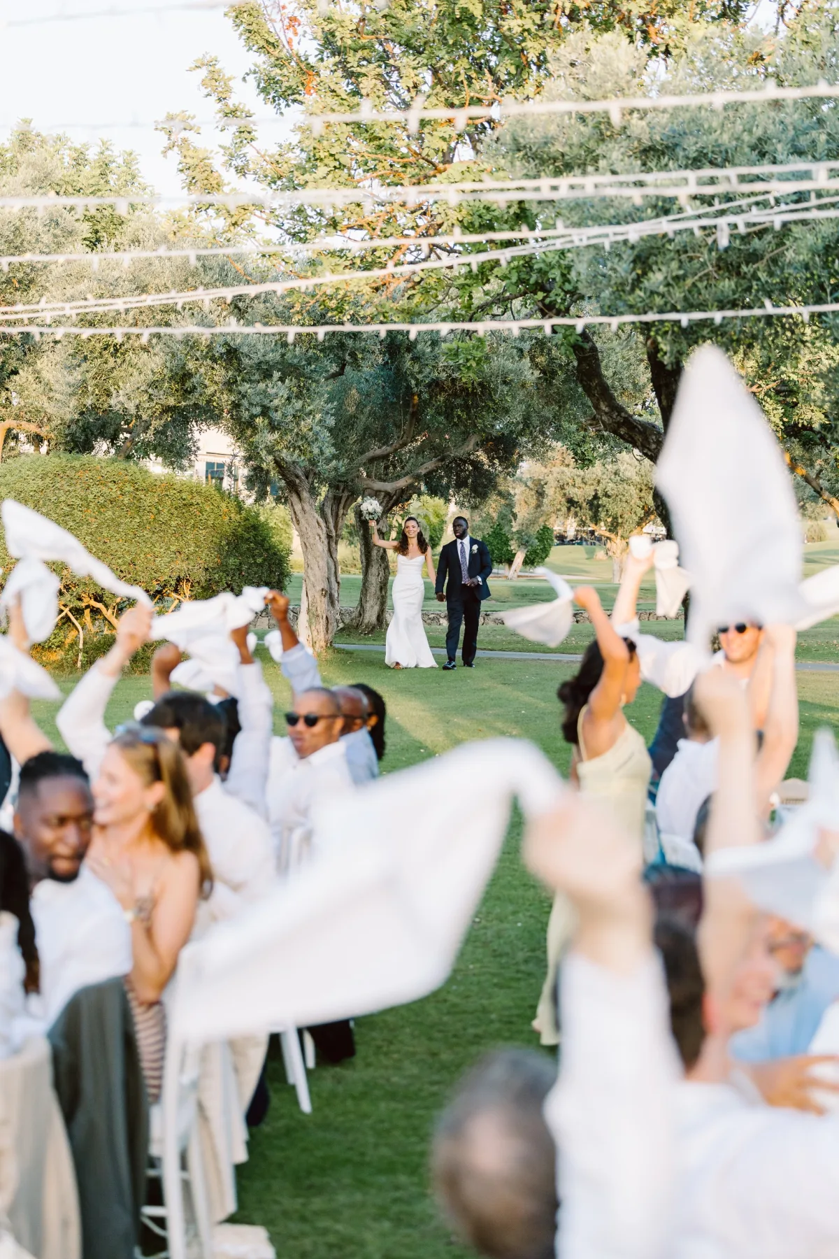 Davetliler peçete sallarken, asma ışıkların altında, Korineum Golf & Beach Resort — Mert Gardiyanoğlu Photography